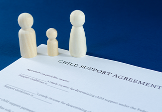 Child support agreement with man, woman and child wooden figures