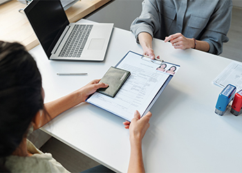 Woman applying for visa giving passport and application form