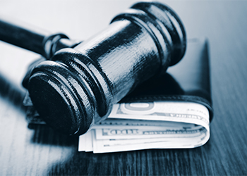 Gavel and money in wallet on wooden background