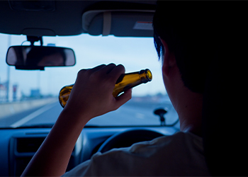 Man drinking beer while driving car