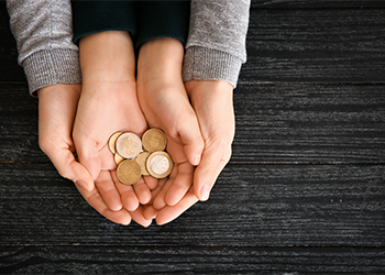 Hands of woman and her son holding coins