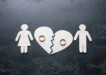 Paper couples near a broken heart with rings