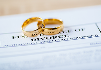 Two broken golden wedding rings divorce decree document
