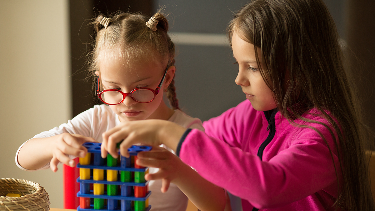 Two children playing together, one with special needs.