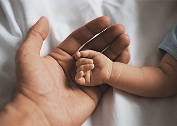 Small hands of baby lying in father's hand
