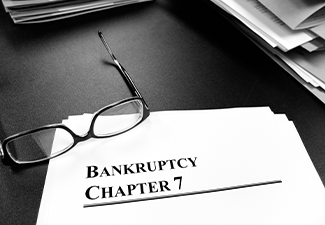 Bankruptcy Chapter 7 Documents on Desk with Glasses