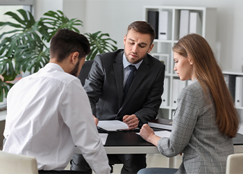 Couples signing divorce papers in attorney office