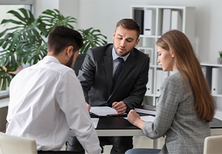 Unhappy young couple visiting divorce lawyer in office