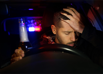 Man with beer bottle in hand pulled over by police