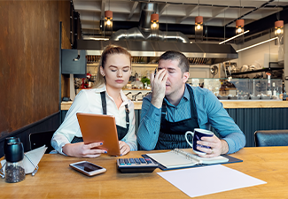 Worried business owners calculating finances