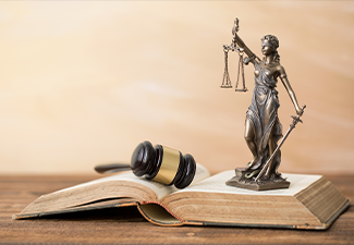 Themis statue on open book and gavel next to it