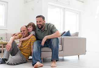 Portrait of male gay couple with adopted child
