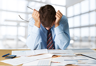 Person stressed with bills on his table