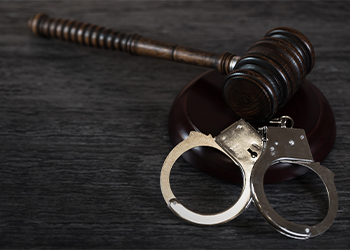 Handcuffs and gavel on table