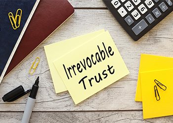 Irrevocable trust text on yellow sticky note