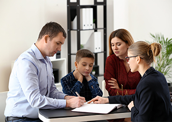 Divorced parents with their son visiting attorney
