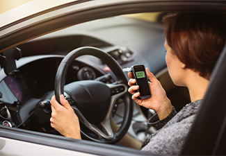 Woman using breath alcohol analyzer in the car