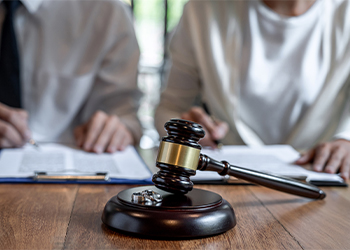 Gavel, Wedding rings and couples signing divorce decree document