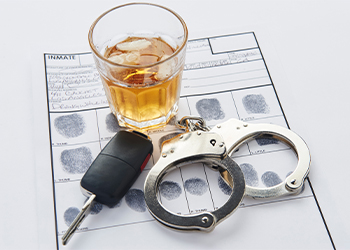 Handcuffs with fingerprints record sheet, keys and glass of alcohol