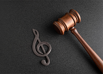 Treble clef next to gavel on black background