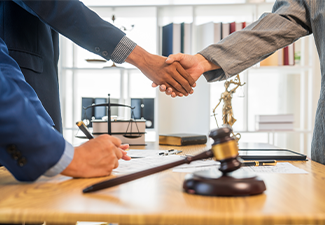 A team meeting of business people and a lawyer in formal suits is taking place at a desk