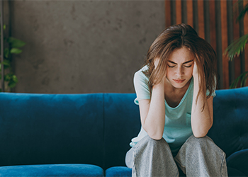 Sad young woman sitting at home