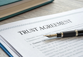 Document labeled Trust Agreement with a pen on top