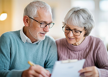 Senior couple in their cozy home, discussing pension plans 