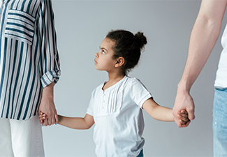 Sad kid holding hands with divorced parents