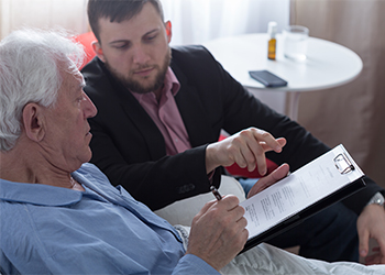 Old man with attorney signing estate planning document