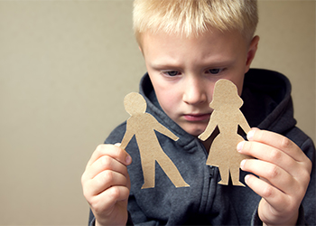 Confused child with paper parents in hand