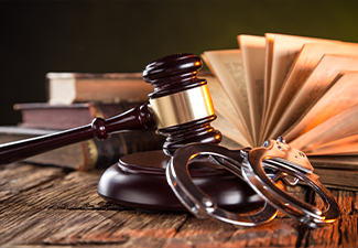 Wooden gavel, handcuff and books on wooden table