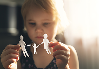 Little girl with paper family in hands