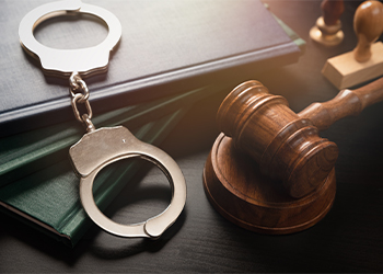Handcuffs and gavel on table