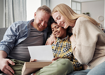 Happy parents embracing their African origin adoptive son