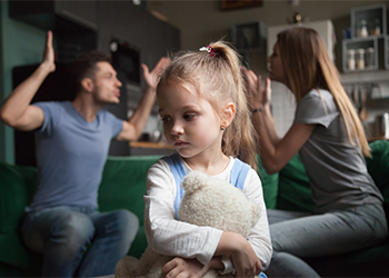 Upset daughter while parents fighting at background