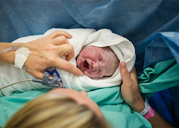 Crying newborn with mother
