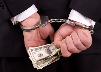 Man on suits with handcuffs and cash in hand