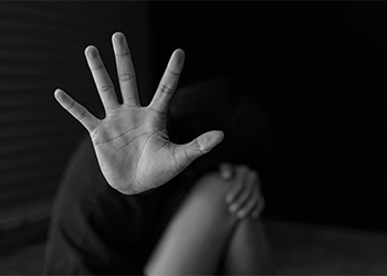Woman showing hands signaling to stop domestic violence