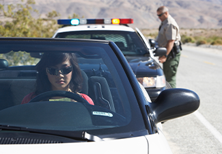 Woman sitting in car being pulled over by police office