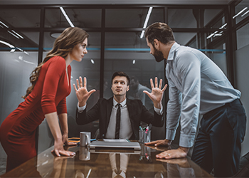 Divorcing couple arguing in front of lawyer