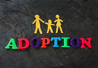 Family paper figure and word ADOPTION