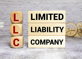 LLC Limited Liability Company written on a wooden cube 