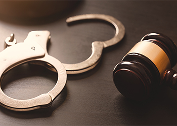 Handcuffs and gavel on table