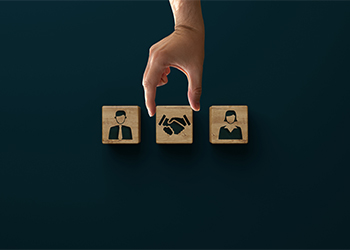 Wooden blocks with icon of man, woman and handshake