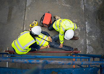 Coworkers helping injured worker in construction site