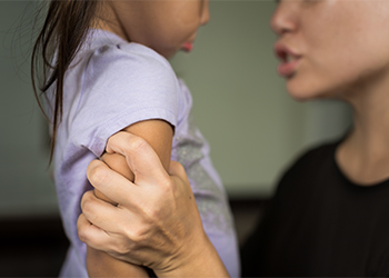 Angry mother holding scared child