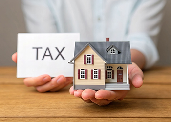 Women holding TAX note and house model in hand