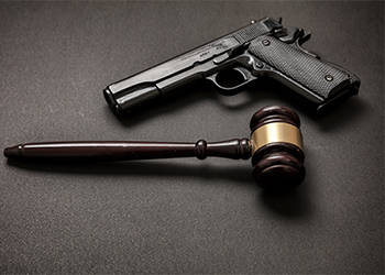 Judge gavel and pistol on black background