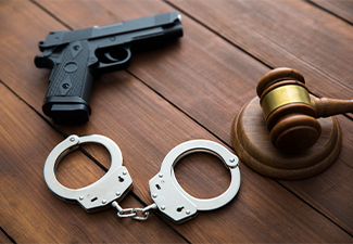 Handcuffs and a judge gavel with gun